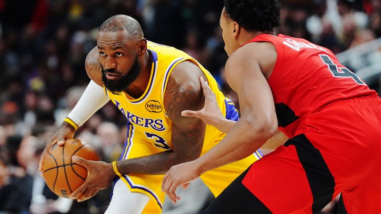Los Angeles Lakers' LeBron James, left, is guarded by Toronto Raptors' Scottie Barnes (4) during second-half NBA basketball game action in Toronto, Thursday, Dec. 4, 2025. (Frank Gunn/The Canadian Press via AP)
